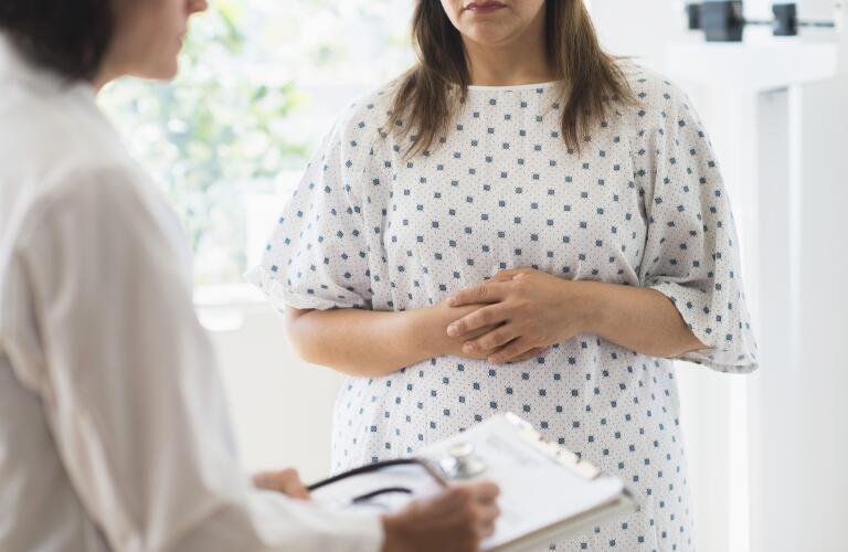 woman-in-patient-gown-listening-to-doctor