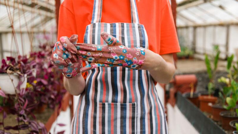 A person wearing gardening gloves