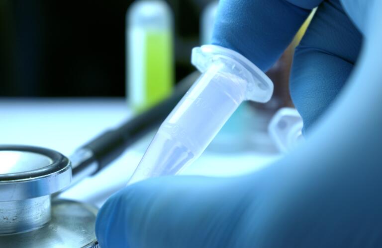 gloved-hand-holding-vial
