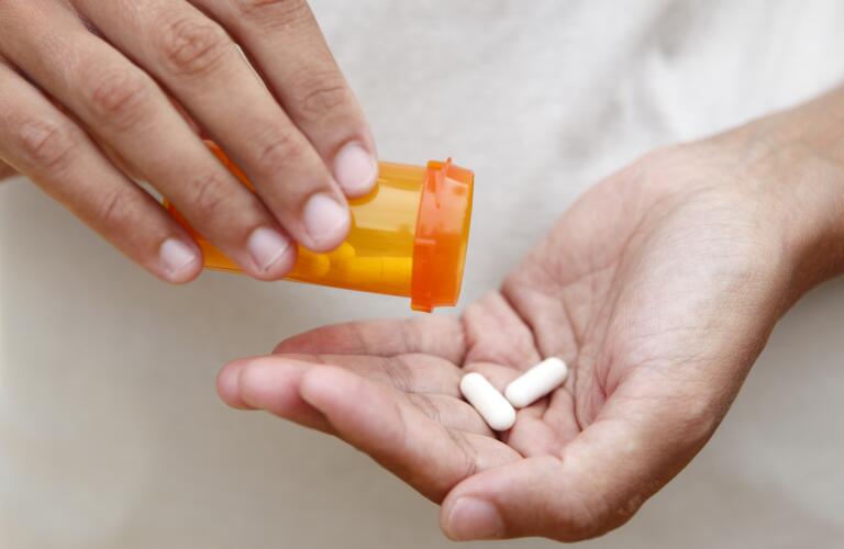 Pills poured into a persons hand