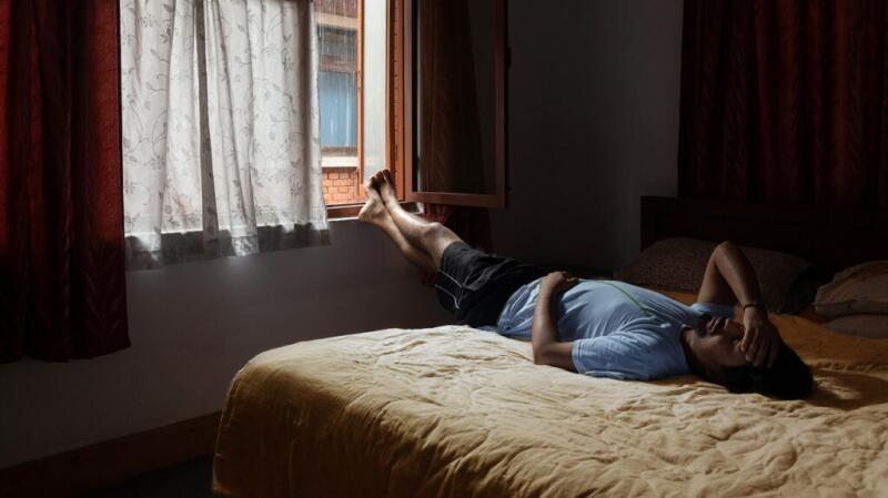 A man laying down with his hands on his stomach and head