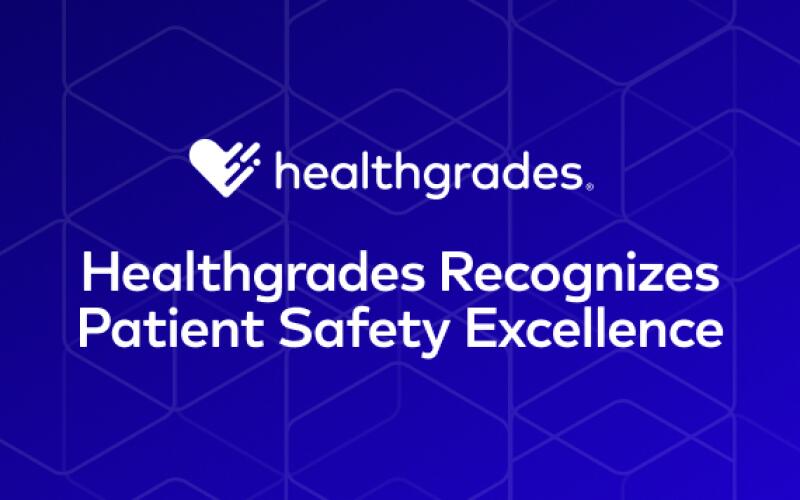 The white Healthgrades logo appears above white text against a blue background with a faint hexagonal pattern. The text reads "Healthgrades Recognizes Patient Safety Excellence".