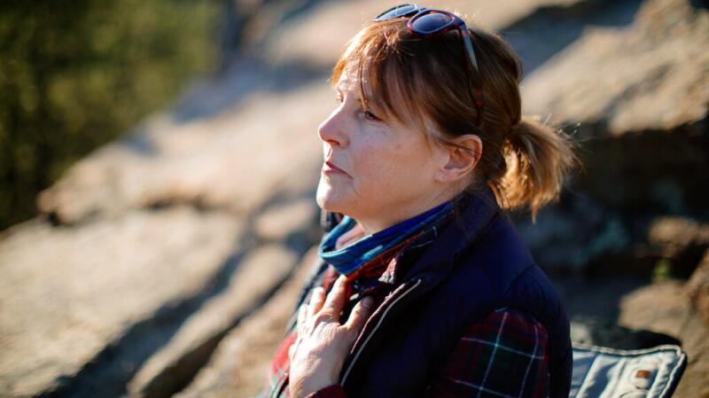 An older woman holding her chest