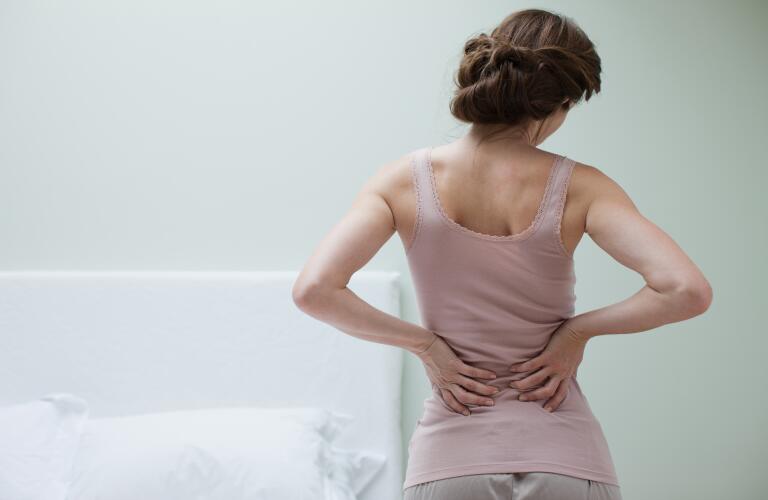 woman-in-bedroom-with-back-pain