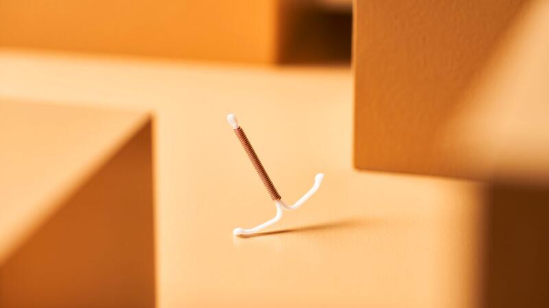 Image of an IUD device against a cream background
