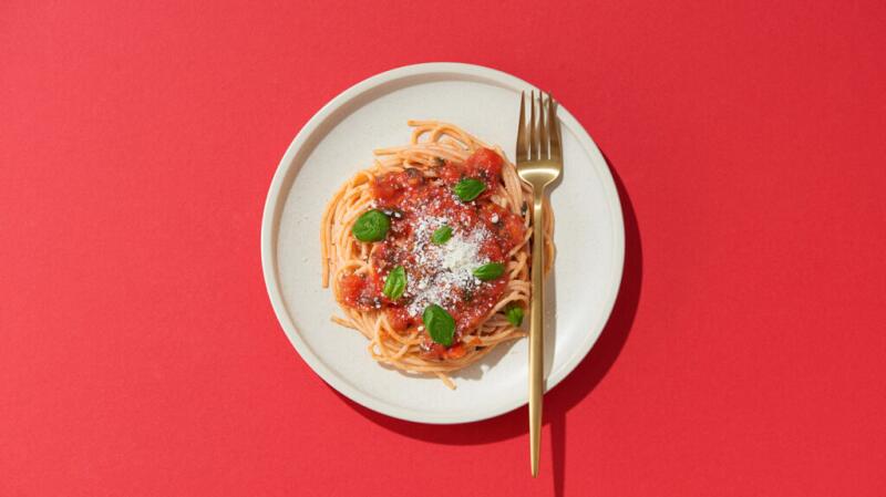 there is a bowl of pasta against a red background