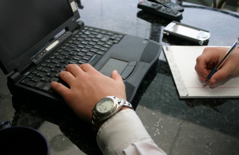 businessman typing and writing