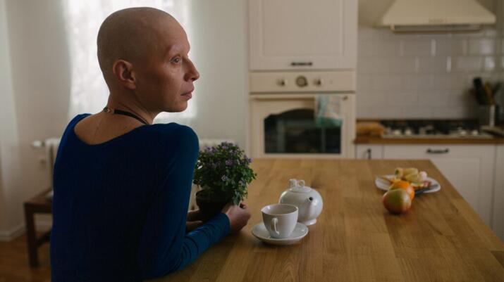 A person with cancer sits at a table