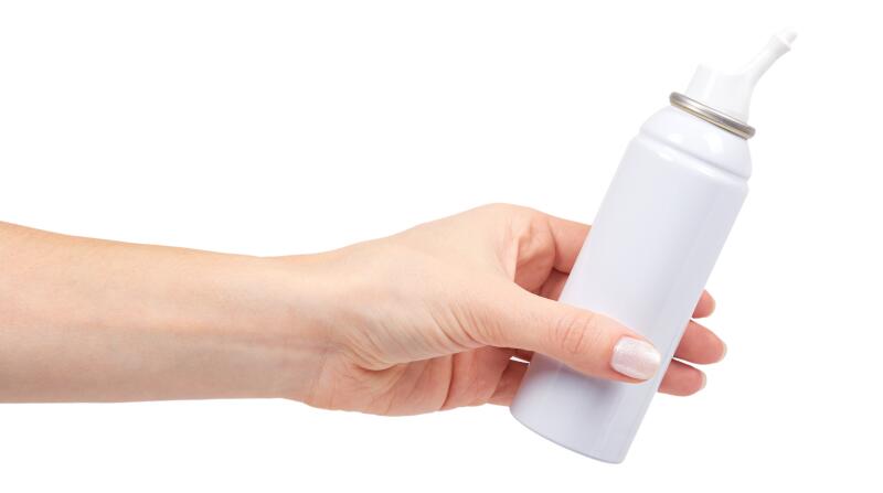 white nose wash spray bottle with hand isolated on white background