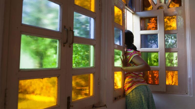 A woman is looking out of a window.