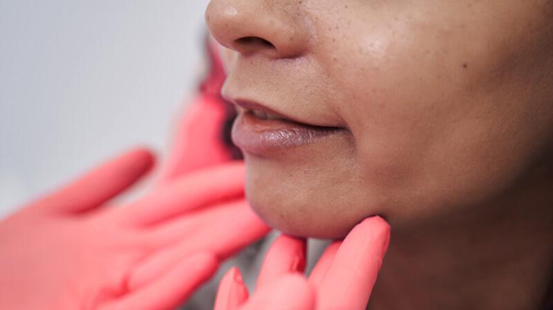 There is a closeup of a person having their face examined.