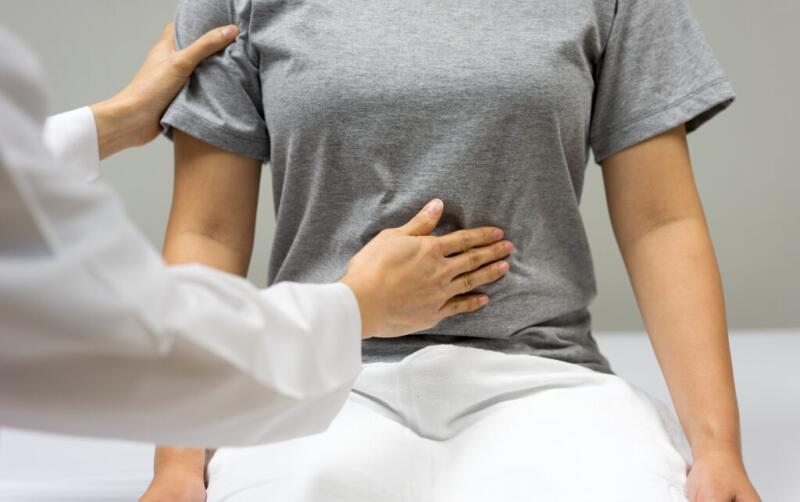 Cropped Hands Of Doctor Examining Woman Abdomen