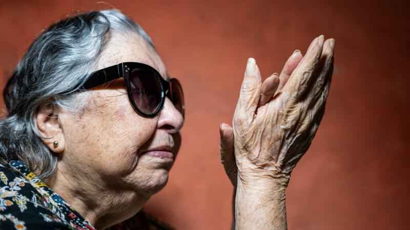 an older woman is looking at her hands