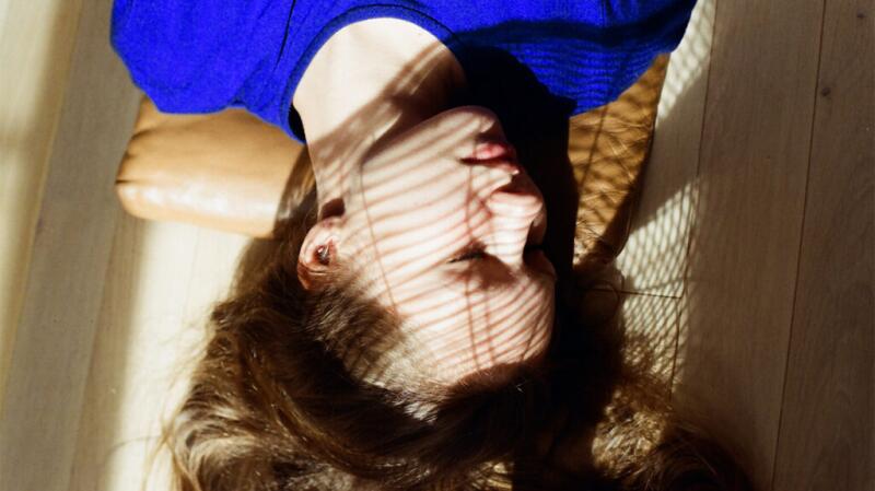 Young woman lying in a web-like shadow