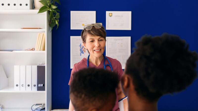 A pediatrician is talking to children.