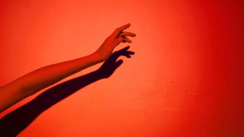 A left arm against a red background