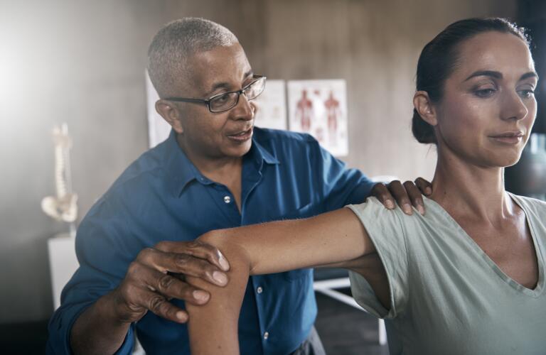 physical-therapist-examining-womans-shoulder