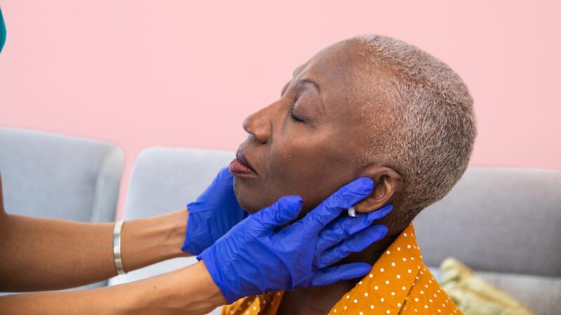 Doctor checking a female's lymph nodes