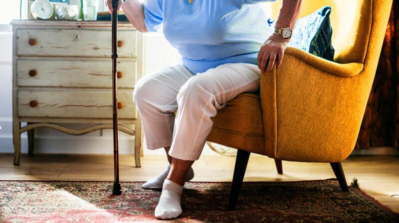 a person is standing up from an armchair