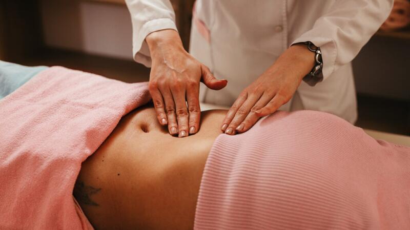 Person receiving an abdominal check from a doctor