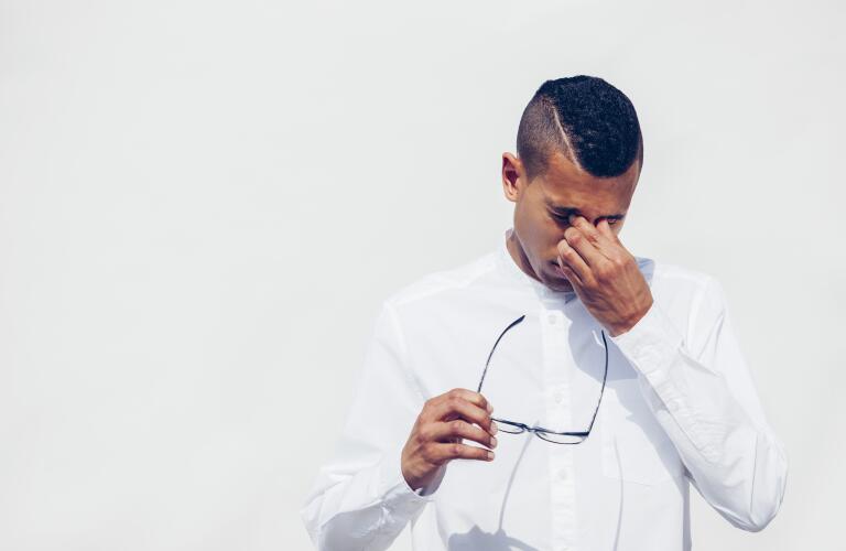 man rubbing his eyes