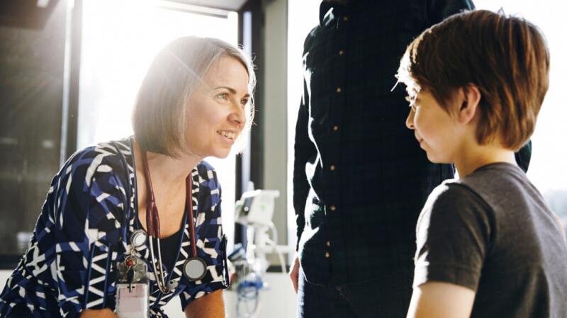 a doctor is smiling and talking to a child with adhd