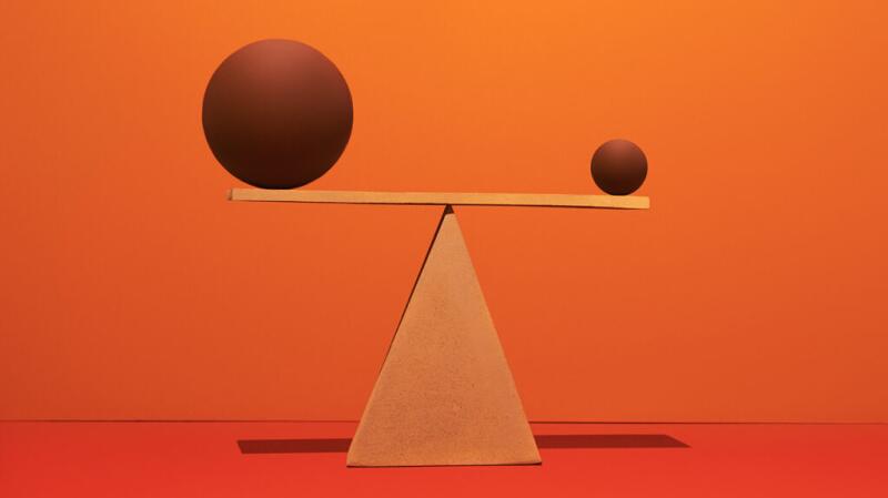 there is a wooden scale with brown wooden spheres at both ends