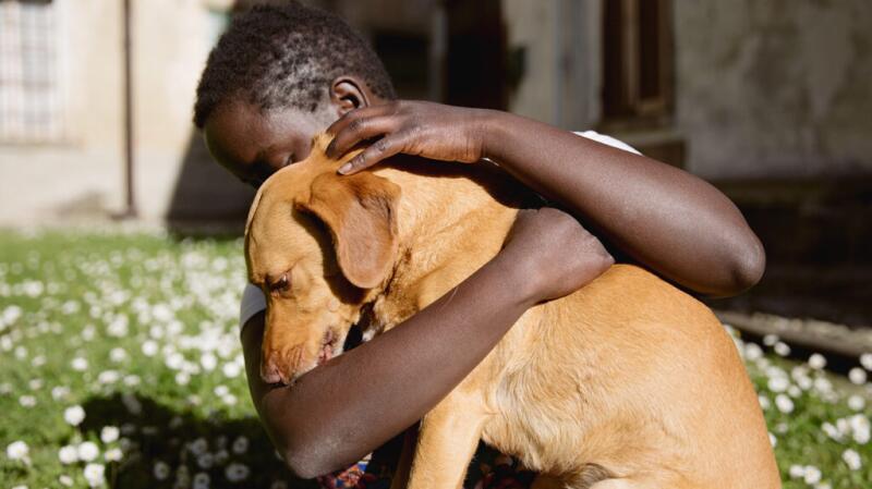 Young person hugging a dog