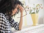 woman sitting at table with headache