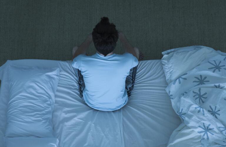 man-sitting-up-in-bed-having-trouble-sleeping
