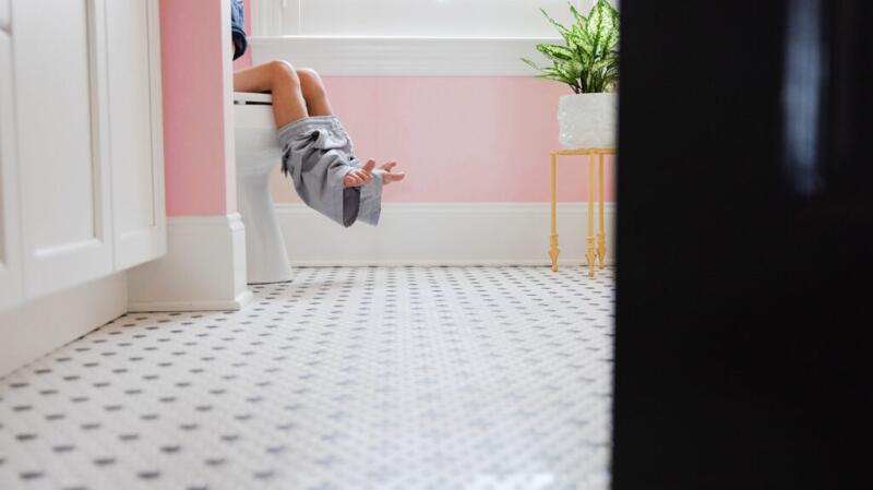 A child is sat on a toilet