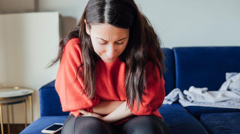 A person is hunched over with stomach pain.