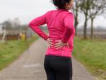 woman clutching back in pain during outdoor exercise routine