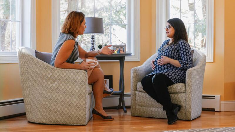 Pregnant woman consulting with doctor or genetic counselor