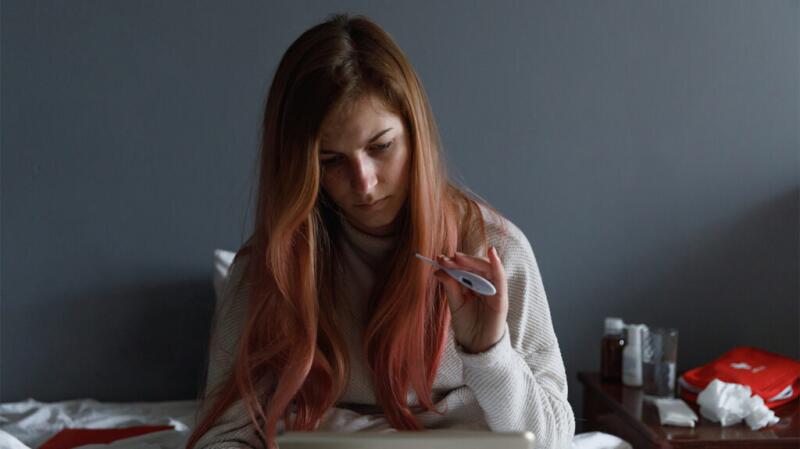 young woman checking her temperature