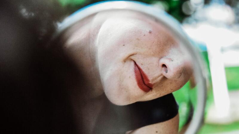 Person looking at their facial skin in a mirror
