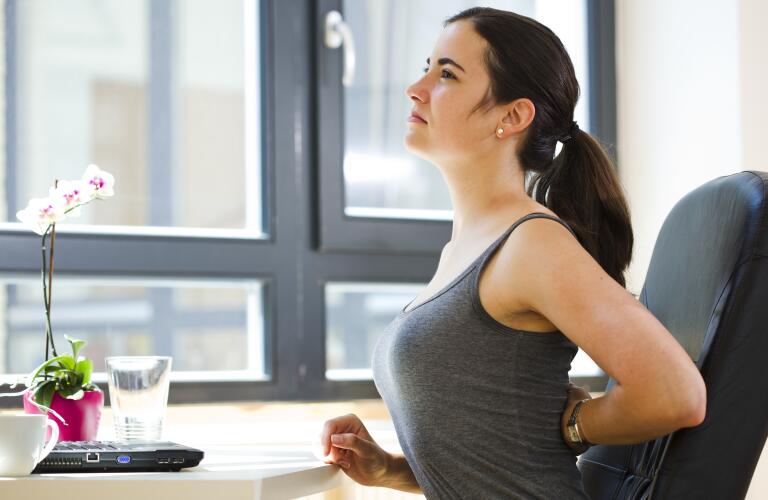 woman-with-sore-back-sitting-at-desk