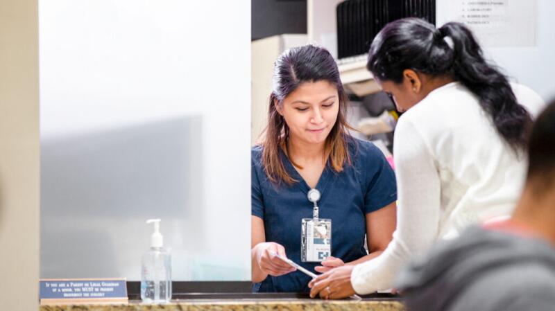 Woman checking in for doctor's appointment at front desk