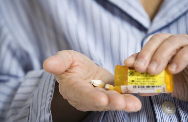 man-pouring-pills-into-hand