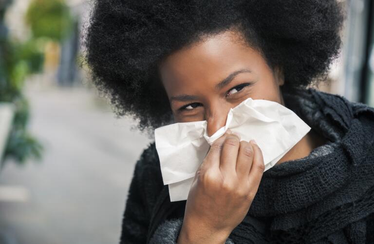 woman-on-street-sneezing