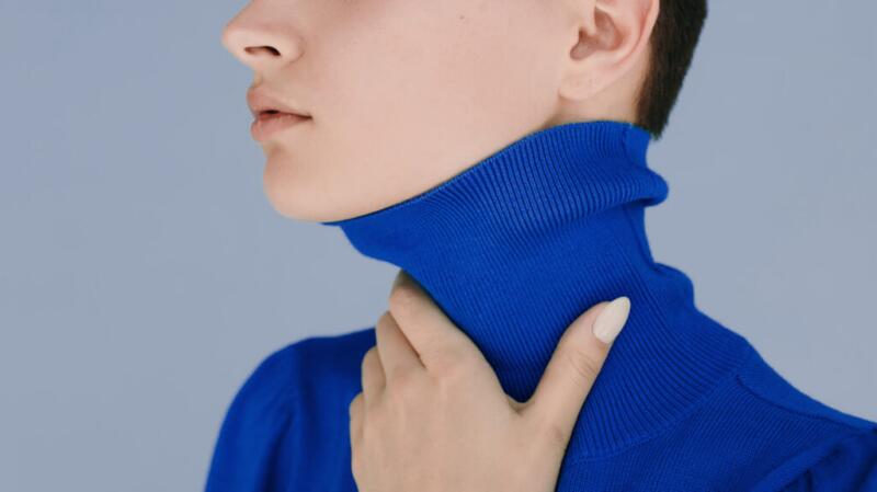 A person with their hand on their throat