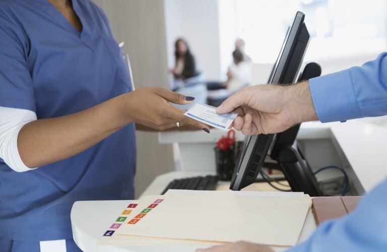 patient handing nurse health insurance card