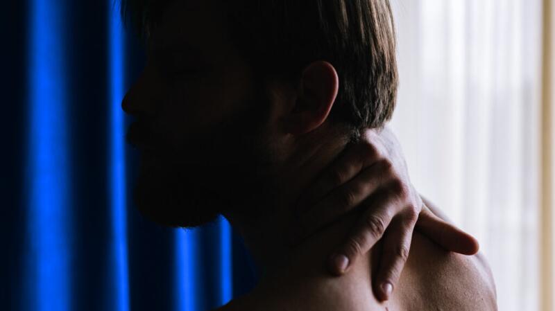 Male touching the back of his neck