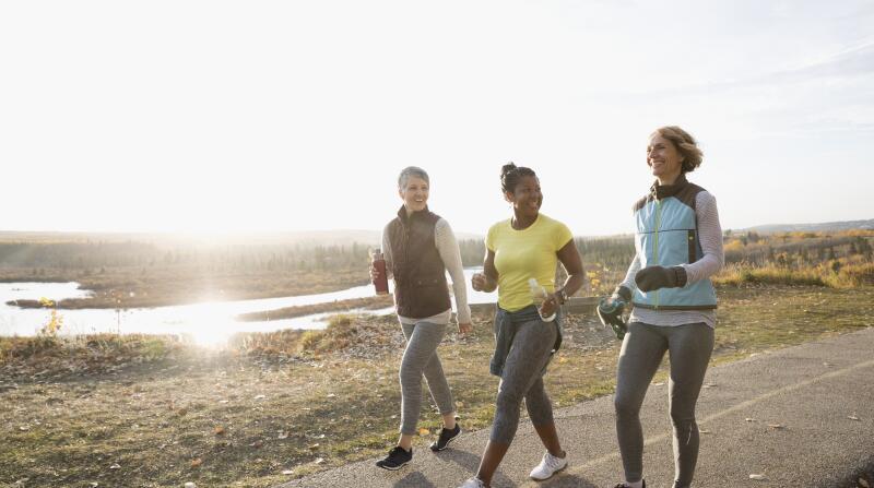 Three happy women walking together outdoors