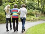 Rear view of three generation females walking on street at park