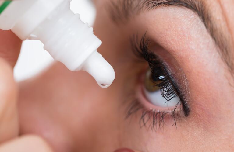 close up of woman putting eye drops into eye