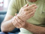 man holding wrist in pain due to injury or arthritis