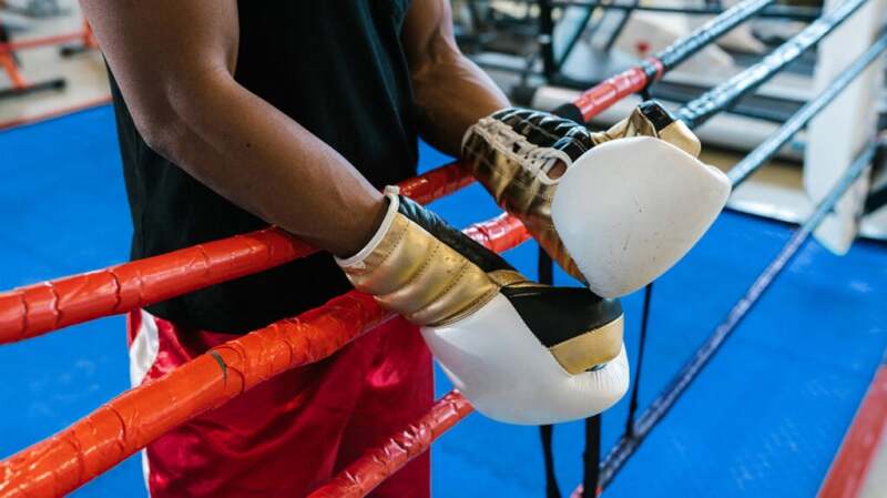 Close-up of person's hands with boxing gloves in a boxing ring