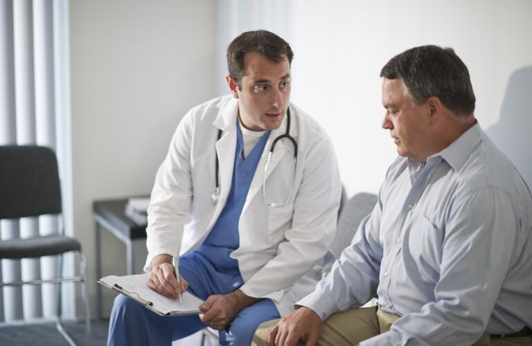 Doctor discussing medical results with male patient in hospital
