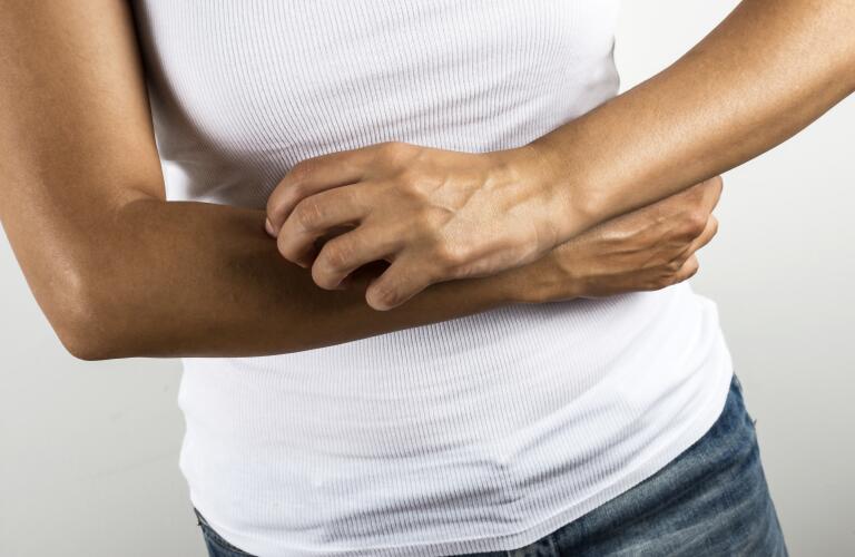 person scratching arm